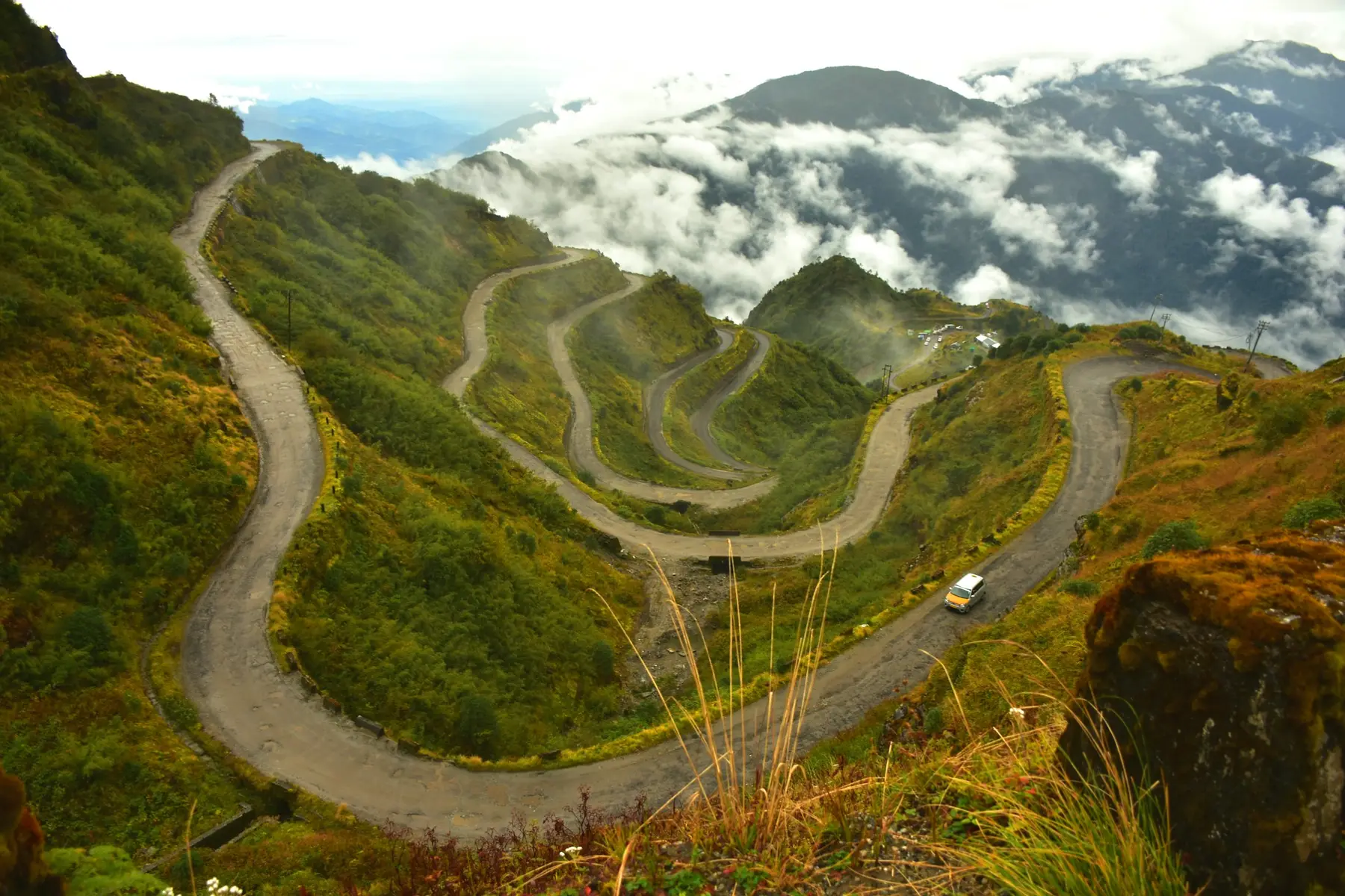 A lone car on a winding Himalayan road