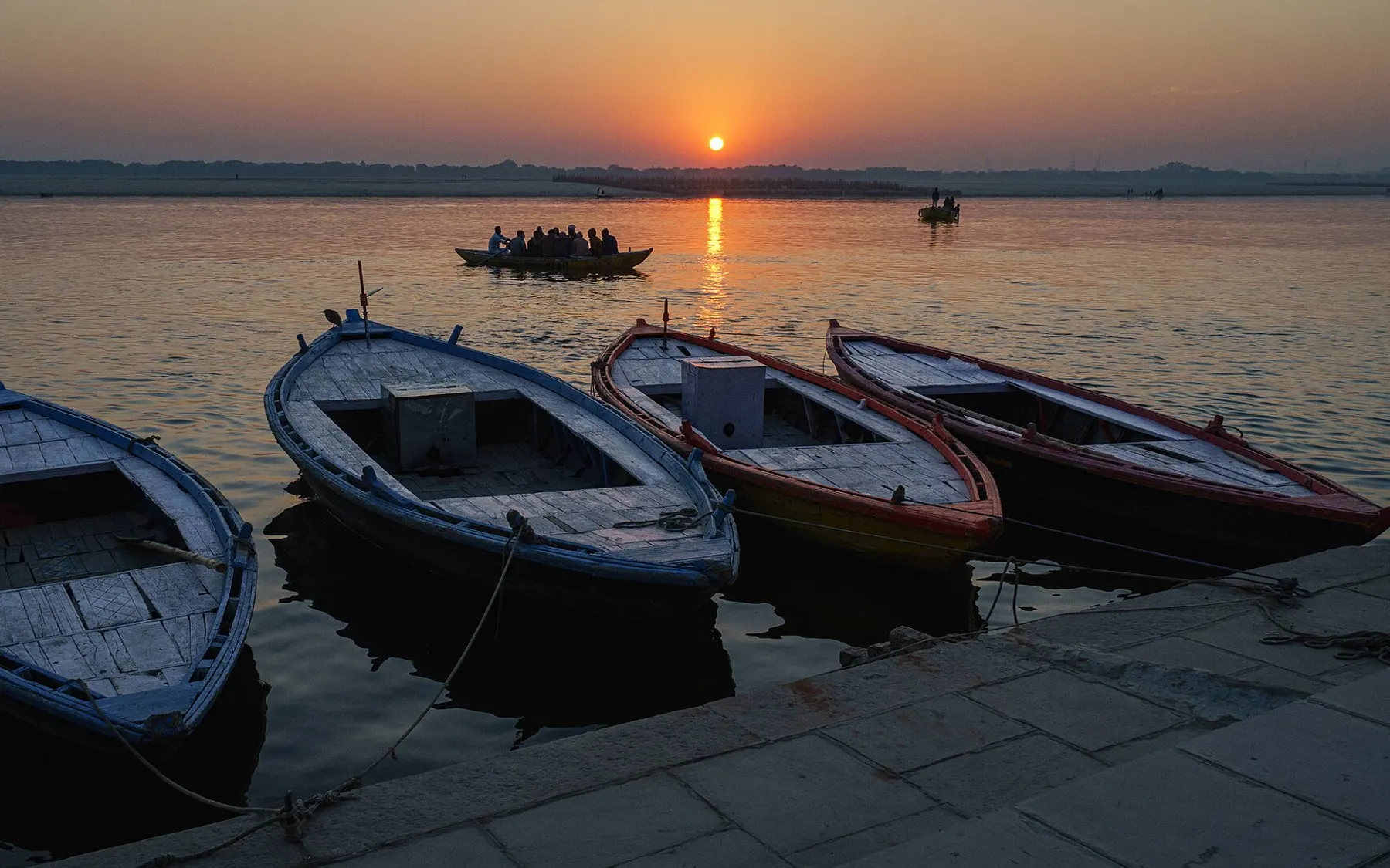 Travellers in a rowing boat on the Ganges at sunrise, Varanasi